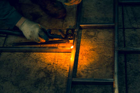 The welder lights the arc and begins to weld the metal structure of stainless steelの写真素材