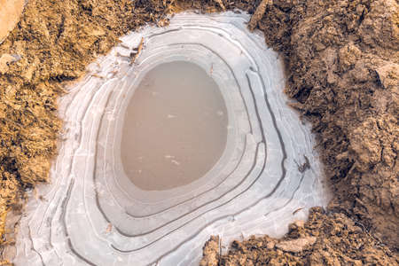The puddle on the ground was covered with ice with bizarre divorces