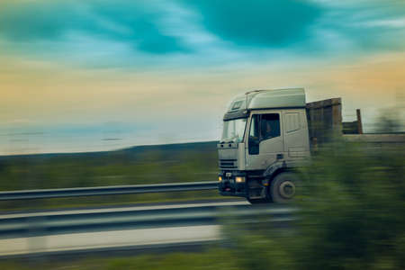 The car at high speed rushes along the motorway in the early July morningの写真素材