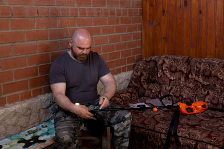 A man shaved and with a red beard sets up a lawn mower