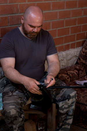 A man shaved and with a red beard sets up a lawn mower