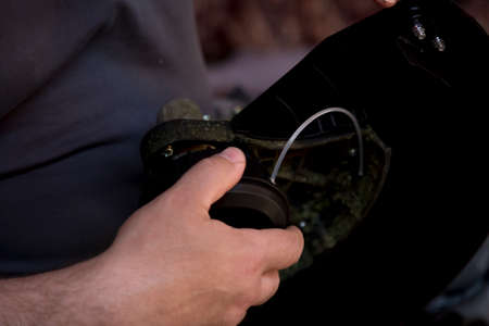 Close-up of hands picking up a power unit of a lawn mower