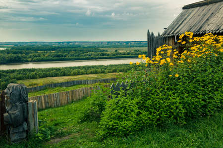 A village garden with a wooden fence against the background of the Siberian river Irtyshの写真素材