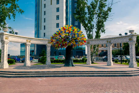 Artificial tree with multi-colored leaves on the background of a wedding arch with pylonsの写真素材
