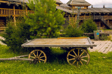 A cart with wooden wheels on a green lawnの写真素材