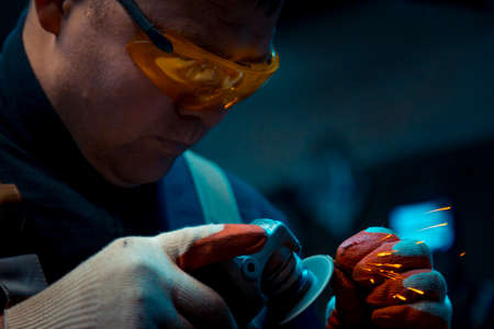 Locksmith man in gloves and yellow glasses at work