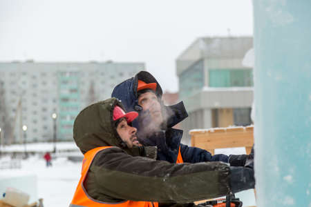 Workers build an ice town from ice blocks for the Christmas holidays