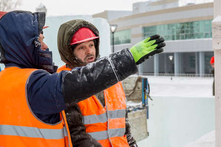 Workers build an ice town from ice blocks for the Christmas holidays