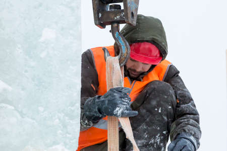 Worker fitter in a protective helmet and reflective vest on the working meast