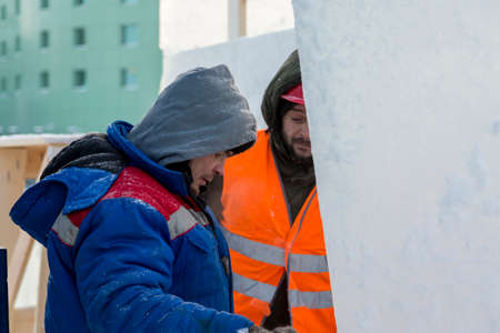 Workers at the construction site of the ice town for a conversation