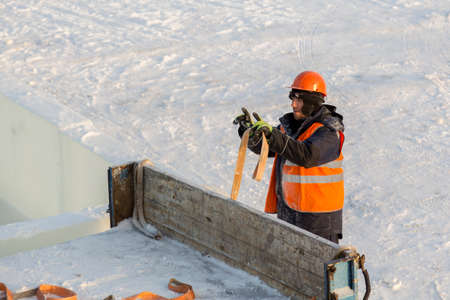 The slinger in the vest and orange helmet guides the movement of the car