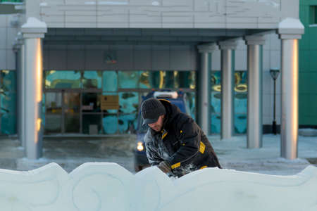 Portrait of an assembler worker in a cap with a black visor in an ice plate