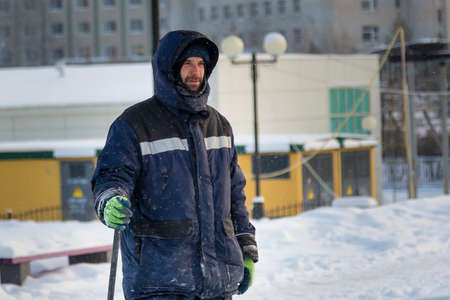 Portrait of an assembler worker in a jacket with a hood at the construction of an ice camp