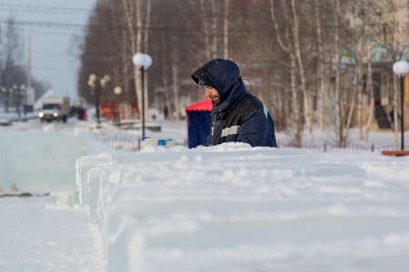 Portrait of an assembler worker in a jacket with a hood at the construction of an ice campの写真素材