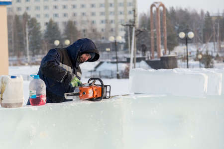 Worker manually fills the saw with gasoline from the can