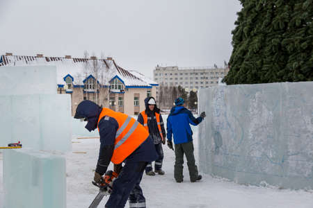Installers at the construction site are building an ice town for Christmasの写真素材