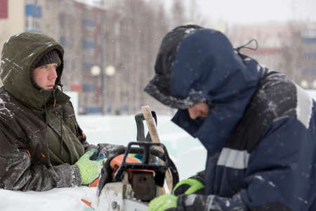 A manual file worker sharpens a chainsaw chainの写真素材