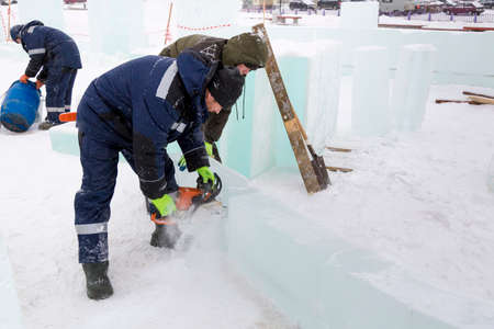 Workers build an ice town from ice blocks for the Christmas holidays