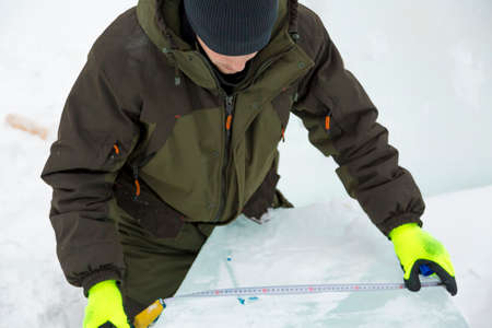 Workman assembler marks the ice block with the help of roulette