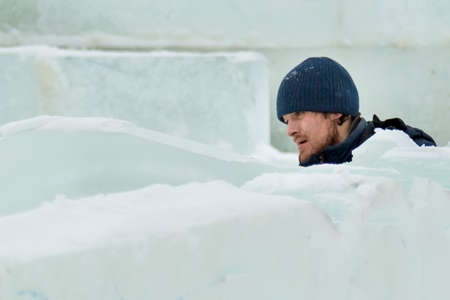 The sculptor cuts an ice figure out of ice with a chisel for Christmas
