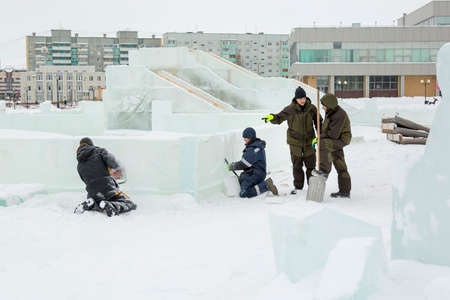 Workers build an ice town for the Christmas holidays