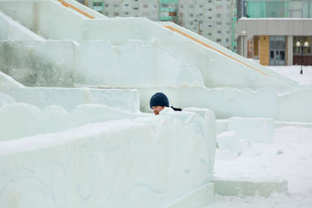 The sculptor cuts an ice figure out of ice with a chisel for Christmas