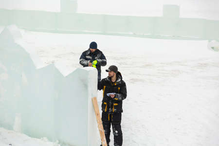 The artist draws the contours of the future ice figure on the ice