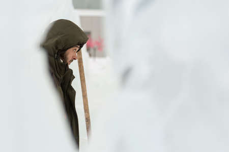 Portrait of a worker in a green jacket with a hood engaged in arranging an ice townの写真素材