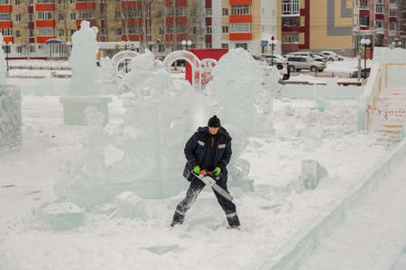Worker with a chainsaw in hand at the assembly site of the ice townの写真素材