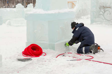Electrician mounts LED flashlight to illuminate the ice figureの写真素材