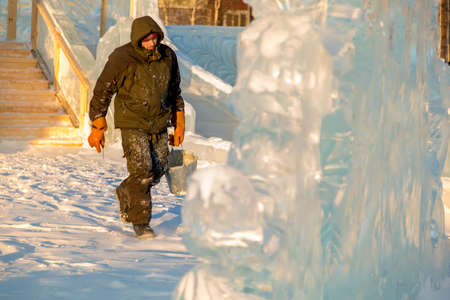 Worker with a bucket in hand at the assembly site of the ice townの写真素材