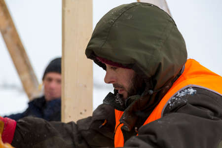 Close-up of a worker's face with a hood on his head