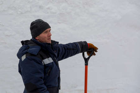 Portrait of a worker shoveling snow in a blizzard