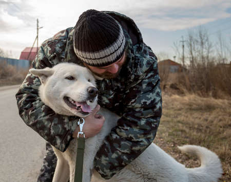 A man in overalls for a walk with a dogの写真素材