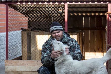 A man in overalls for a walk with a dogの写真素材