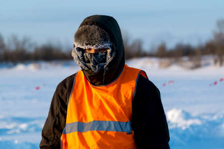 The average plan of the worker in protective overalls, ice of a frozen reservoir, whose face was covered with hoarfrost.の写真素材
