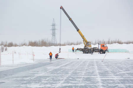 Slingers pull ice panels out of the lane using a truck craneの写真素材