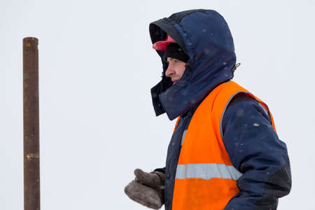 Portrait of a worker in a blue jacket with a hood on his headの写真素材