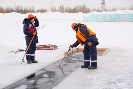 Installers in life jackets rafting ice panels to the lane with the beogramsの写真素材