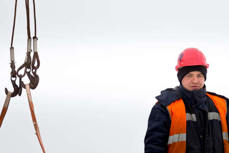 An installer in an orange vest and helmet on an assembly siteの写真素材