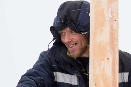 An installer at the construction of wooden formwork from boards