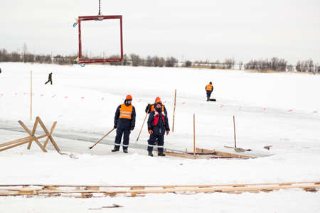 Worker slingers in orange reflective vests and helmets ship ice panels