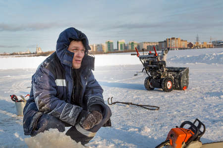 Portrait of an installer in a blue jacket with a hood on his headの写真素材