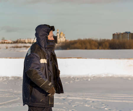Portrait of an installer in a blue jacket with a hood on his head