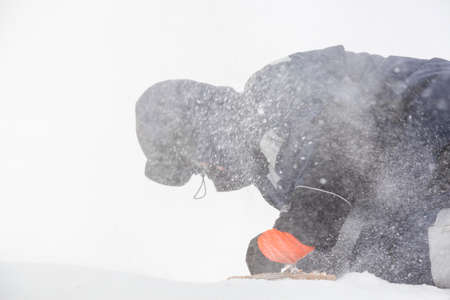 The builder cleans the ice panel with a wire brush from snowの写真素材