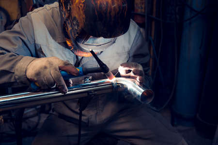 TIG welder welds elbow to polished stainless steel pipeの写真素材