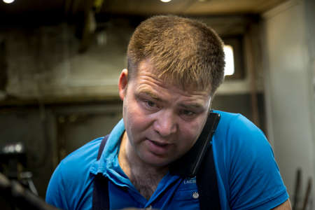 Close-up portrait of a man in the workplace with a mobile phone