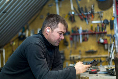 Close-up portrait of male worker at workplace talking on cell phone