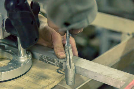 The worker fixes the part to the base with a clamp