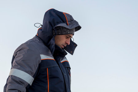 Portrait of a worker in a blue jacket with a hood